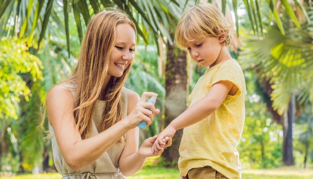 anyuka a kisfiát szúnyogriasztó spray-vel fújja be