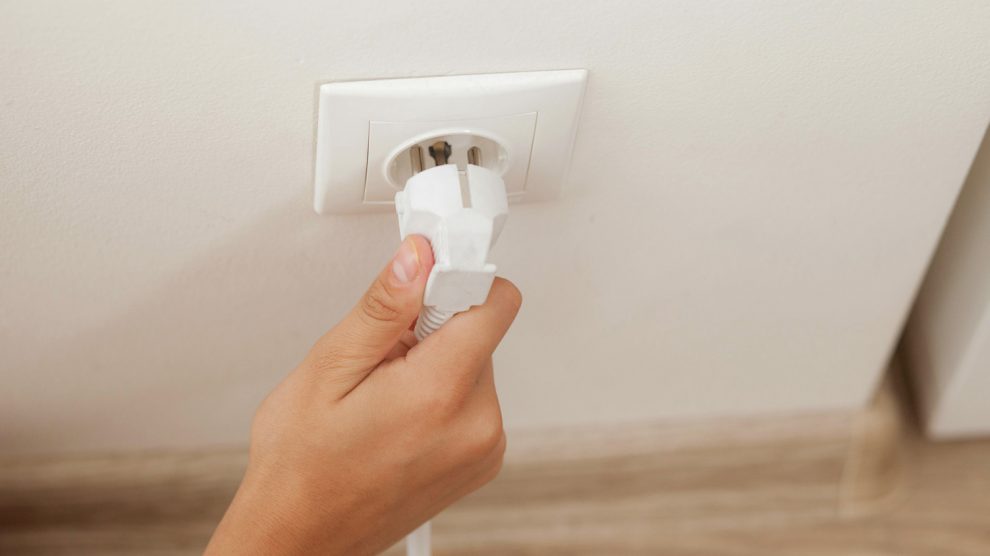 konnektorból kihúzza a töltőt egy nő