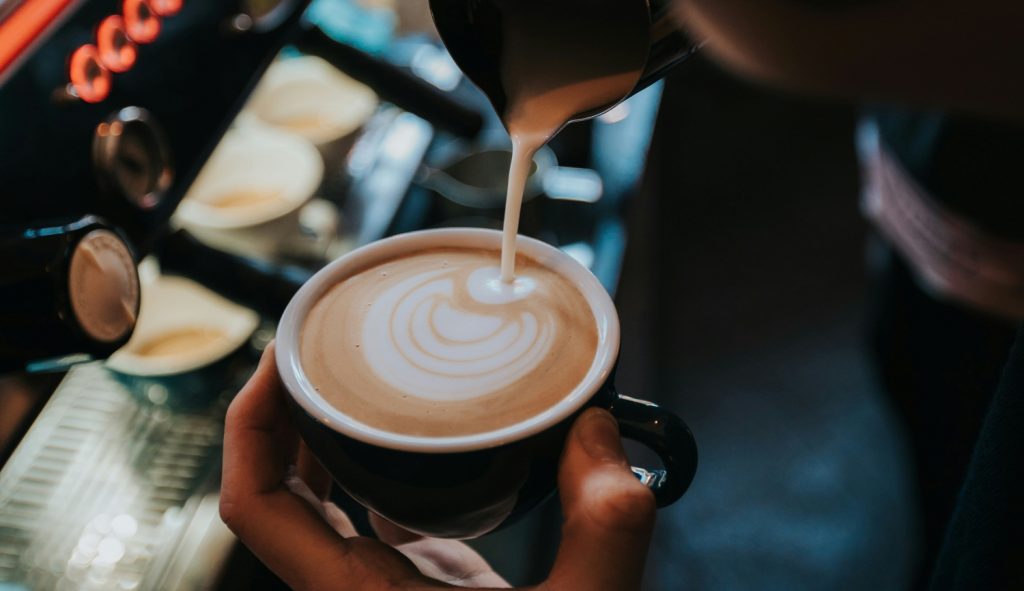 kávéra tejhabot önt a barista