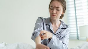 lány vakarózik az ágyban mert megcsípte a szúnyog