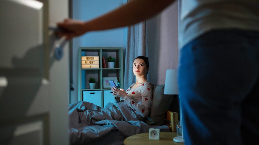 Tinédzser lány este az ágyban tablettel