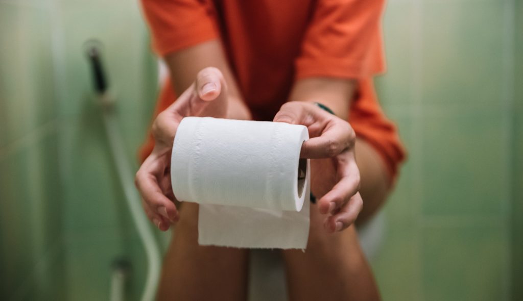wc-n ül egy nő wc-papírt tart a kezében