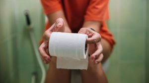 wc-n ül egy nő wc-papírt tart a kezében