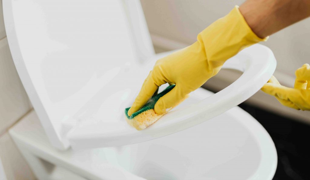 nő gumikesztyűben wc-t takarít