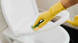 nő gumikesztyűben wc-t takarít