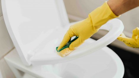 nő gumikesztyűben wc-t takarít