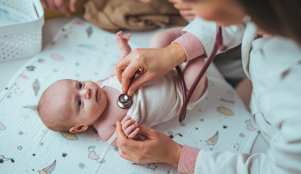 Orvos sztetoszkóppal ellenőrzi az újszülött egészségét