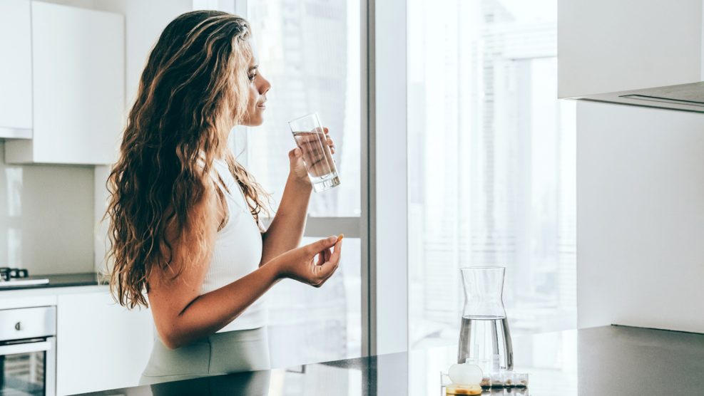 ashwagada étrendkiegészítőt vesz be egy nő a konyhában
