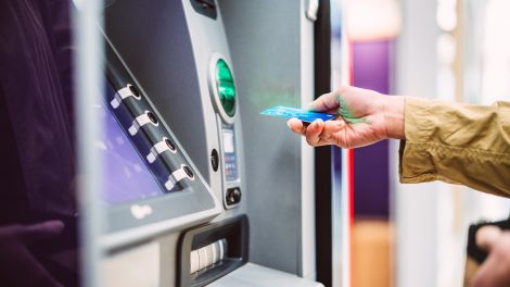 bankkártyát dug a bankautomatába egy nő