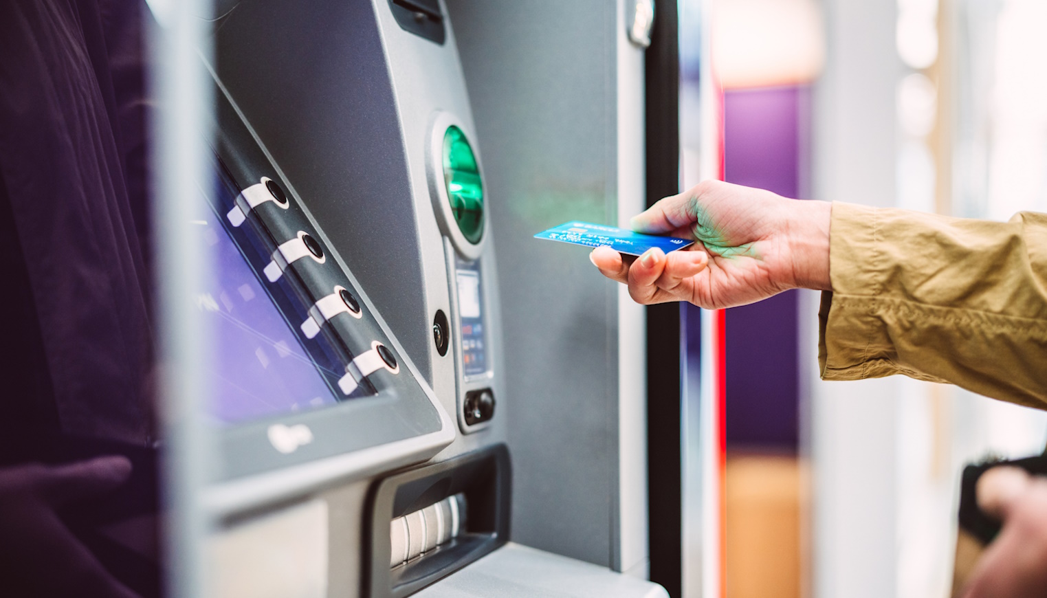 bankkártyát dug a bankautomatába egy nő
