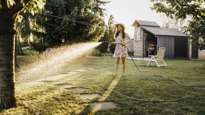 kánikulápan locsolja a gyepet füvet egy lány