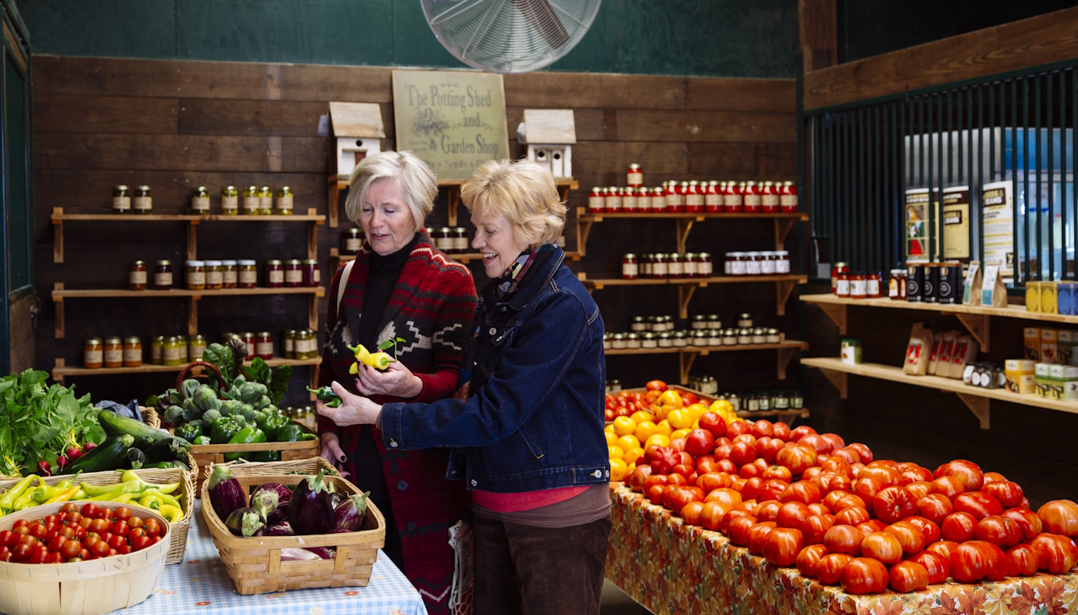 két idős hölgy zöldséget válogat a szupermarketben