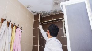 penész a fürdőszoba plafonján nézi egy férfi