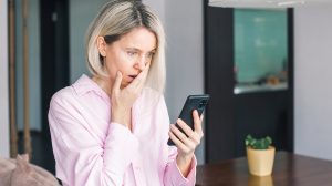 ijedt nő telefonnal a kezében
