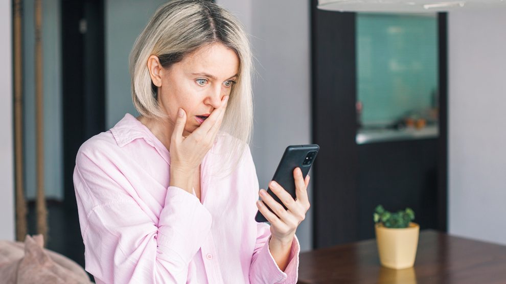 ijedt nő telefonnal a kezében
