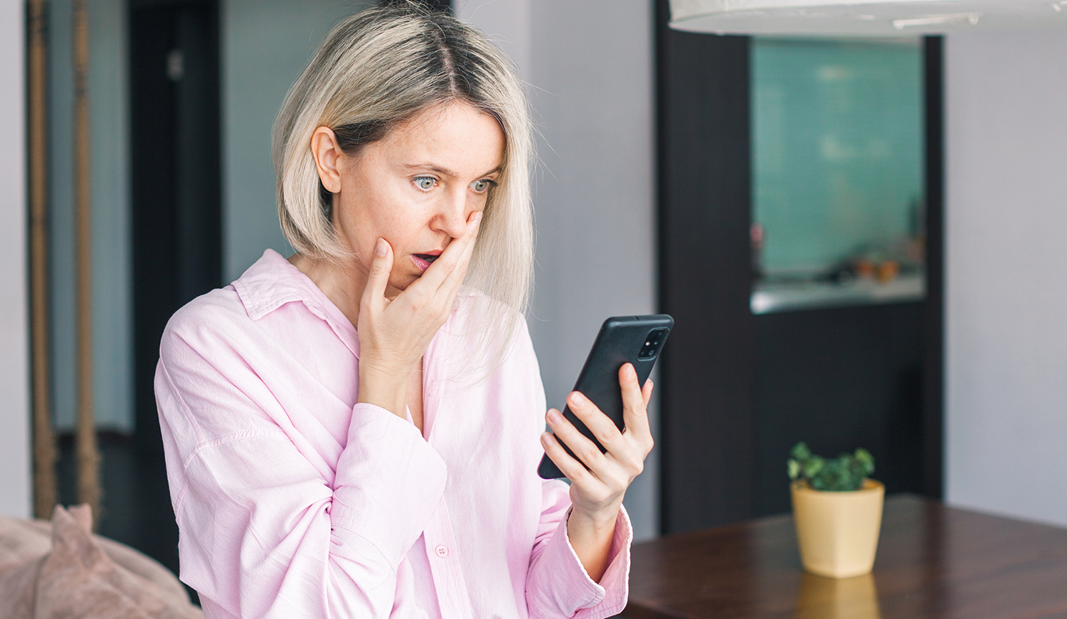 ijedt nő telefonnal a kezében