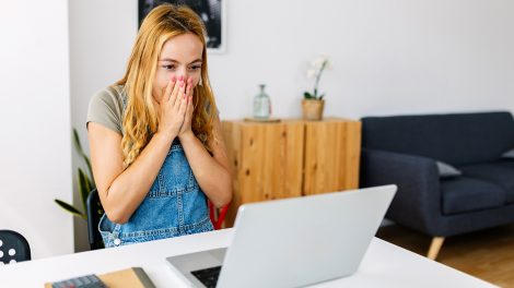 fiatal lány meglepődik a laptop előtt