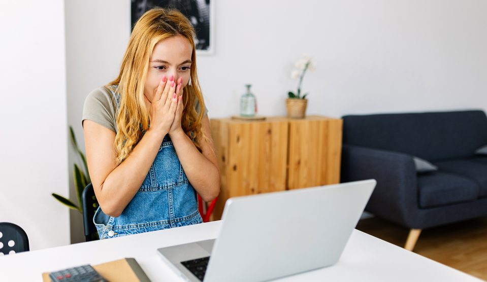 fiatal lány meglepődik a laptop előtt