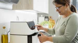 air fryert kapcsol be egy nő a konyhában