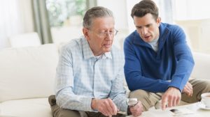 bélyeggyűjtő albumot néz nagypapa az unokájával