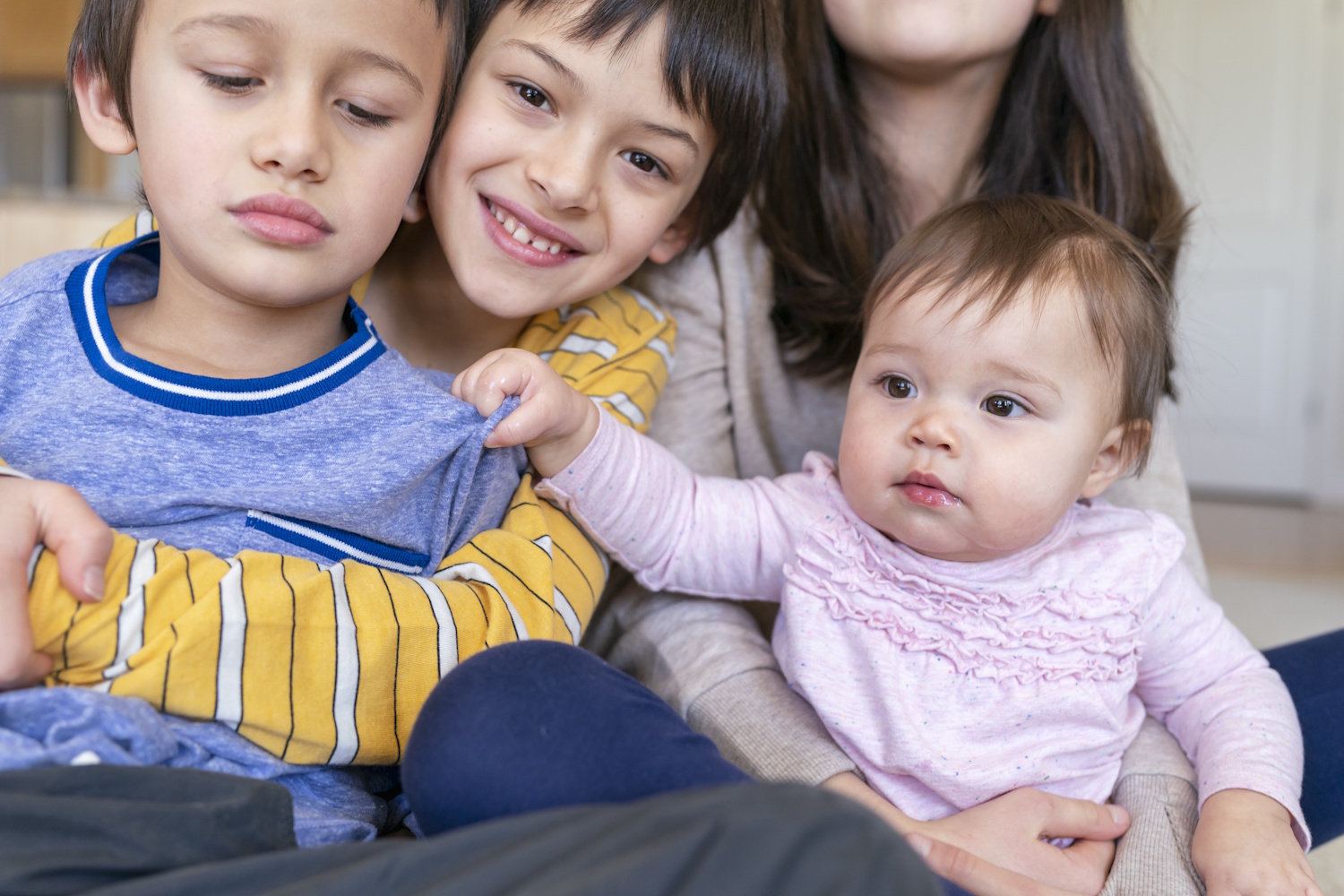 Két kisfiú, egy kislány és egy kisaba ölelgetik egymást