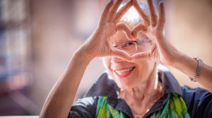 idős nő szívet mutat a kezével