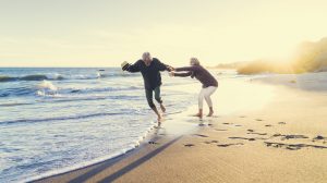 boldog idős pár táncol a tengerparton