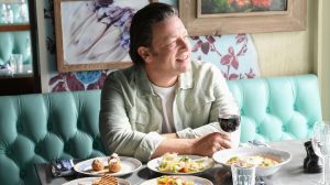 jamie oliver asztalnál ül és mosolyog