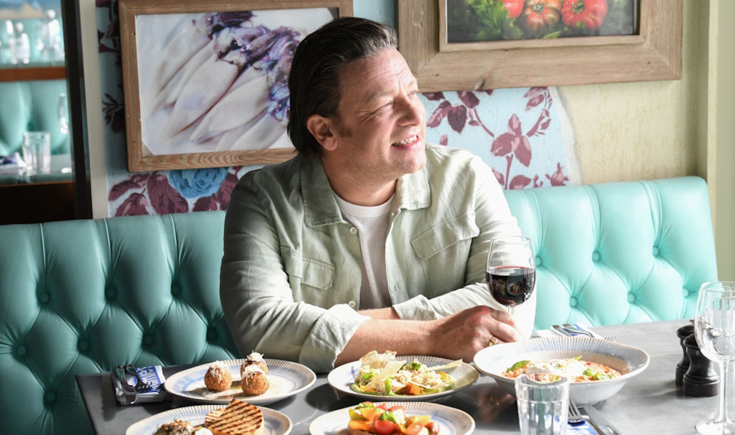 jamie oliver asztalnál ül és mosolyog
