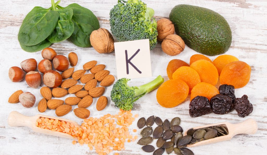 Zöldségek, gyümölcsök és magok egy asztalon, amik K-vitamint tartalmaznak