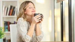 teát iszik egy nő a konyhában