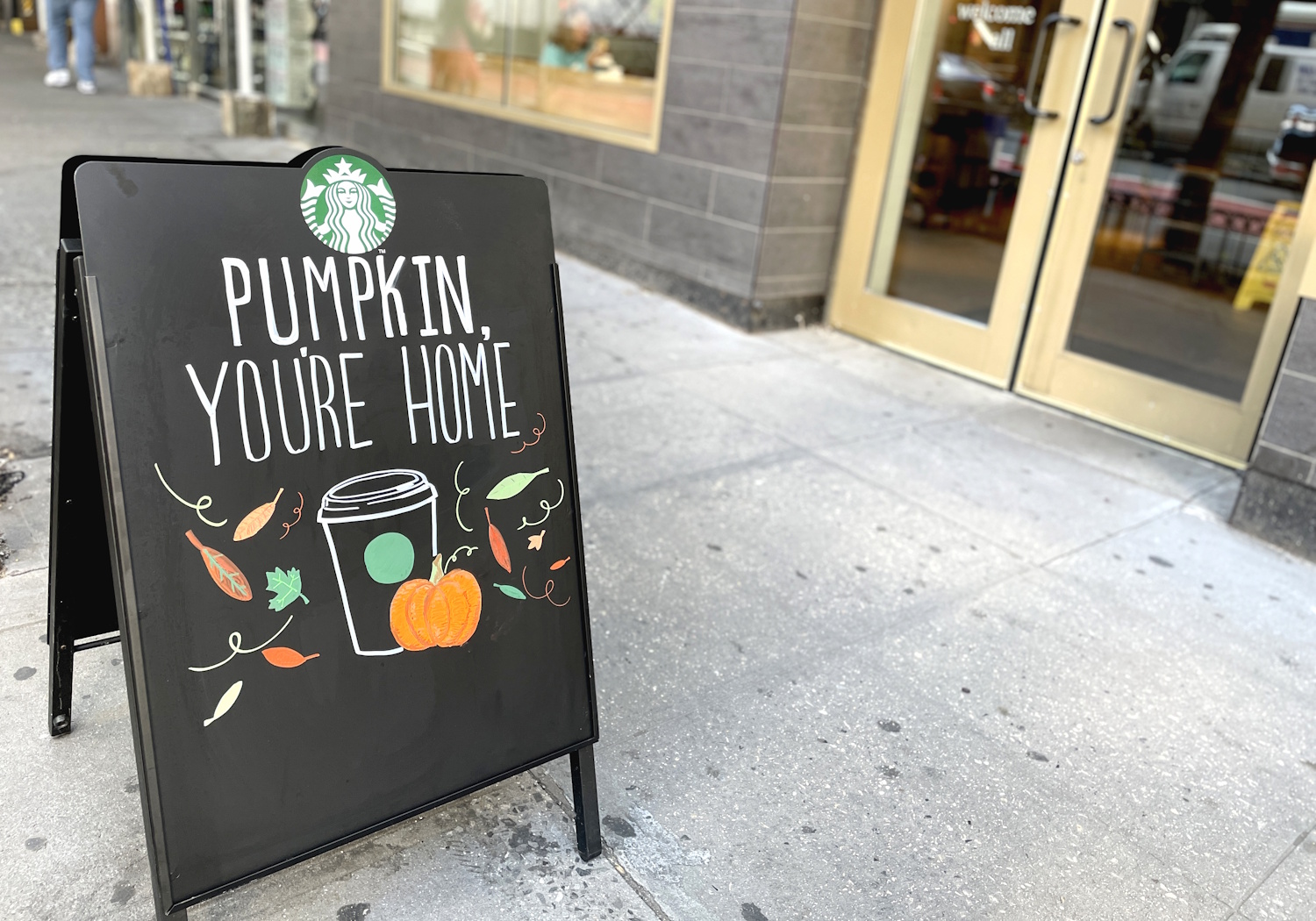 Pumpkin Spice Latte hirdető tábla egy Starbucks előtt