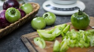 zöld paradicsom feleszeletelve vágódeszkán