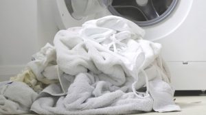 fehér ruhák kupacban a mosógép előtt