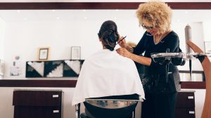 barna hajú nő ül a fodrászszékben