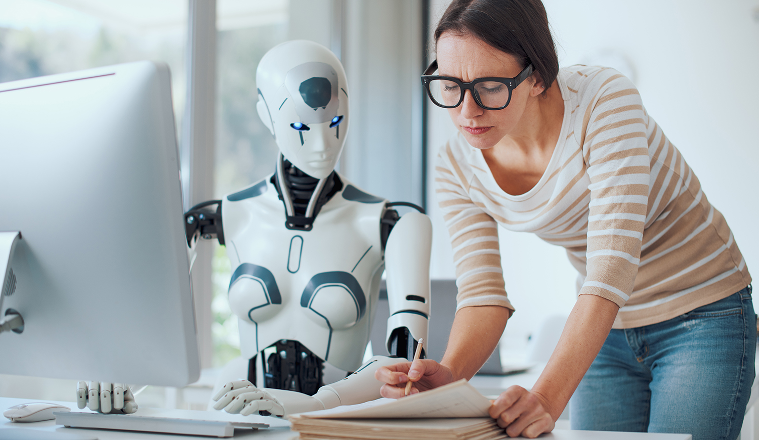 Nő és mesterséges intelligencia robot dolgozik együtt az irodában