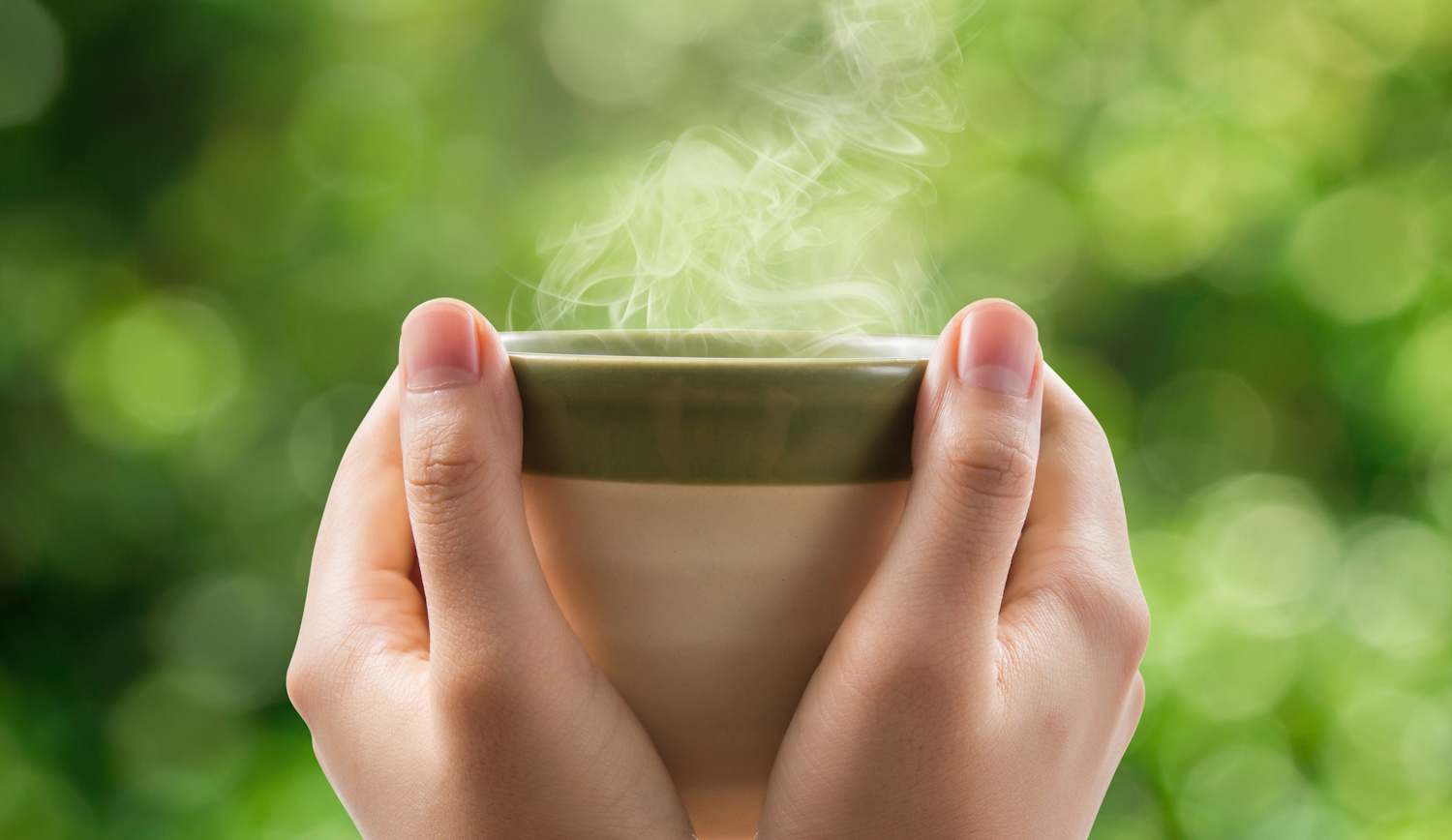 gőzőlgő tea csészében, nő kezében