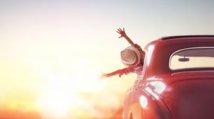 boldog nő autóban a naplementében
