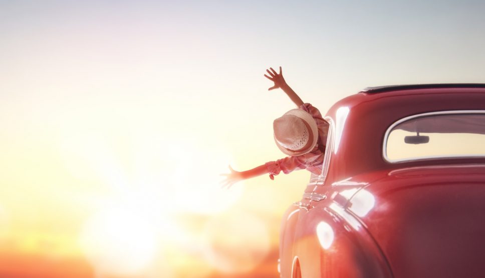 boldog nő autóban a naplementében