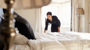 Egy nő éppen kitakarít egy szállodai szobát