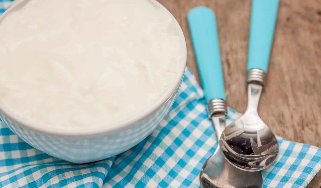 joghurt két kanállal kék kockás terítőn
