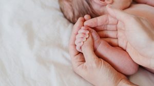 Anya újszülött gyerekét fogja
