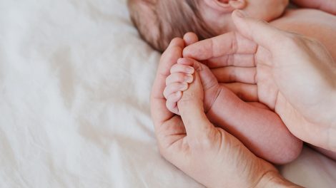 Anya újszülött gyerekét fogja