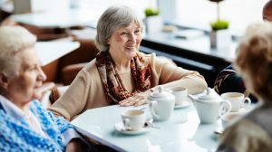 három idősebb nő vidáman kávézik