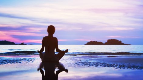 Egy tengerparton meditáló nő