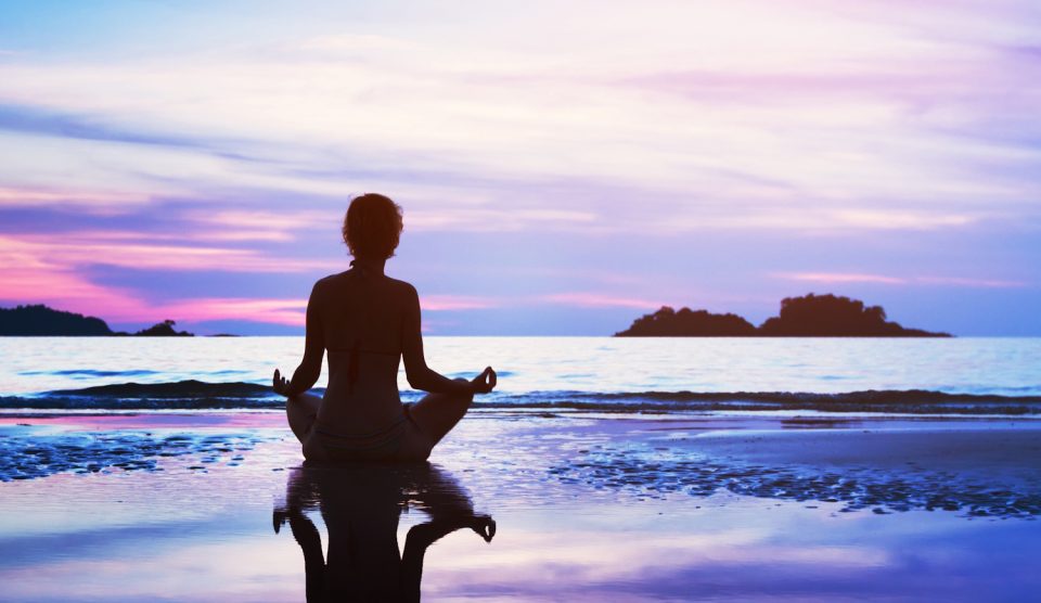 Egy tengerparton meditáló nő