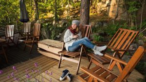 őszi kertben ül egy nő sapkában