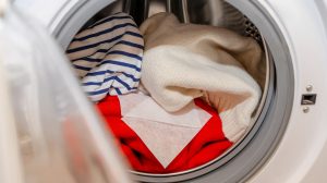 színfogó kendő fehér és piros ruhák mellett a mosógépben