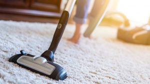 nő a szőnyeget porszívózza