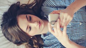 nő az ágyban a telefonját nyomkodja